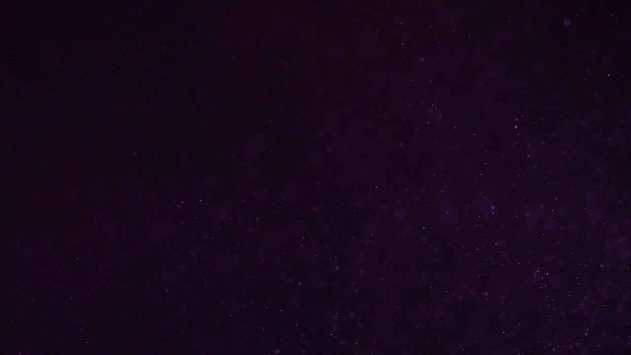 Particelle di polvere viola fluttuanti su sfondo scuro