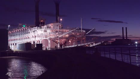 beautiful shot of a large mississippi paddlewheel riverboat docked at night near new orleans