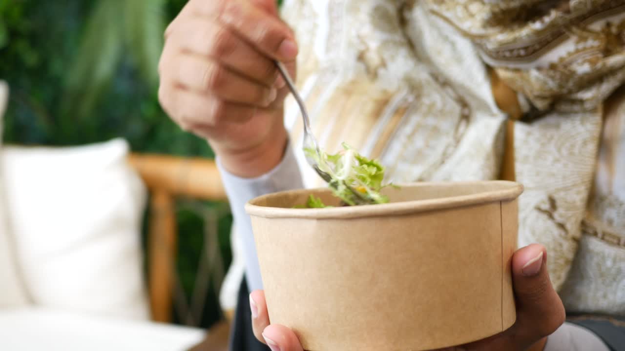 mujer en hijab disfrutando de una comida al aire libre
