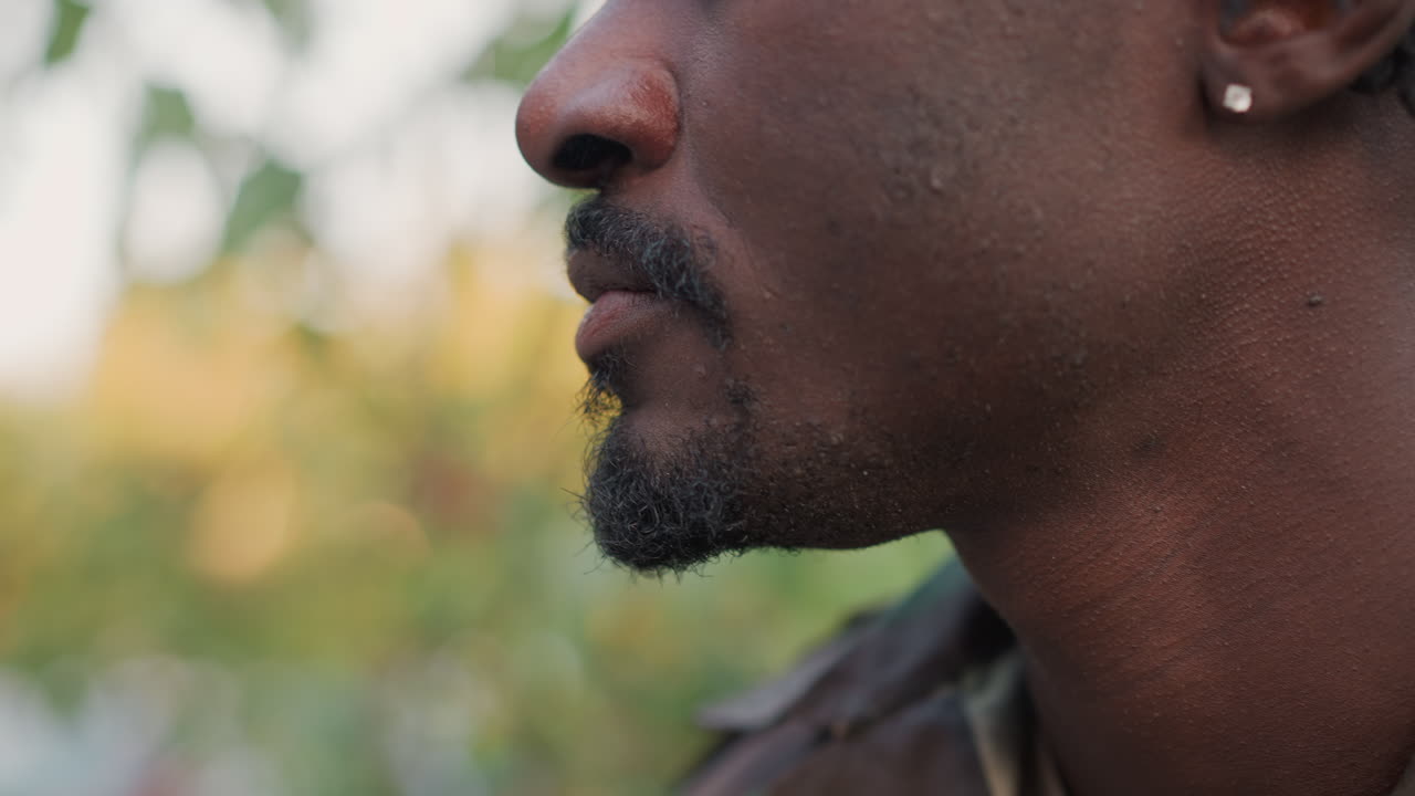 primer plano de médico de campaña aceptando una bebida durante una patrulla; un hombre en camuflaje recibe una taza de una mano invisible; un pequeño momento de alivio y atención capturado con un perfil detallado; luz cálida del atardecer y silenciosa gratitud