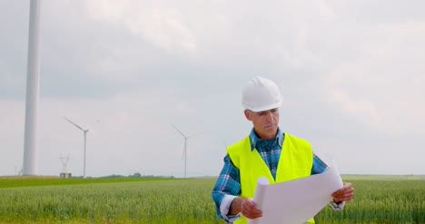 Ingeniero-Trabajando-En-Plan-De-Lectura-De-Granja-De-Molinos-De-Viento