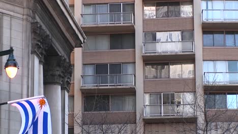 the camera zooms in on windows and a balcony of a large residential hotel in a major city