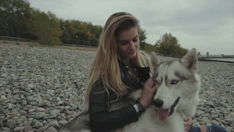 woman and her husky dog at the beach