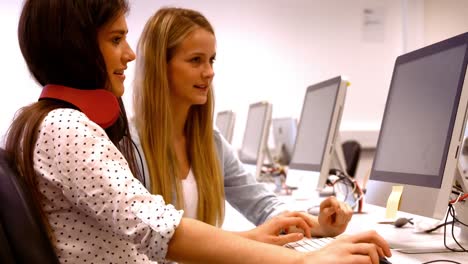 dos estudiantes trabajando en computadoras
