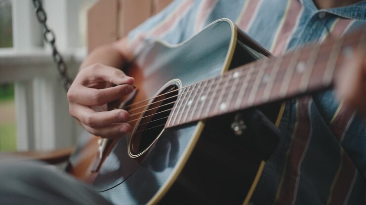 Man playing acoustic guitar on a porch