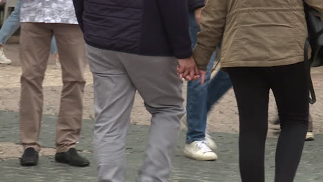 couple walking hand in hand on city street