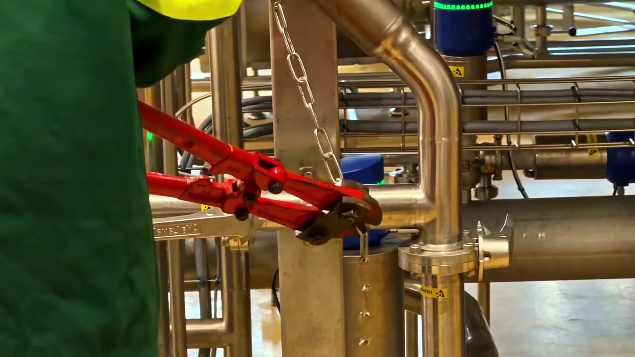 Primo piano di operaio industriale che aziona una valvola in un ambiente di fabbrica