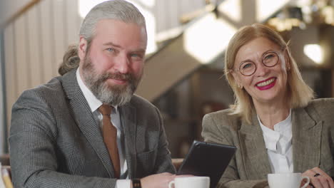 portrait of cheerful senior business partners in restaurant