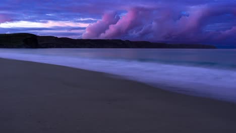 time lapse of the sunsetting over a sandy beach as the tide comes in