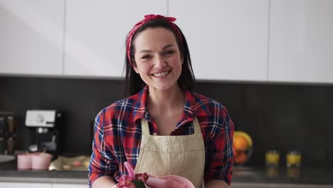 happy woman in apron presents box with macaroons cookies decorated with flowers