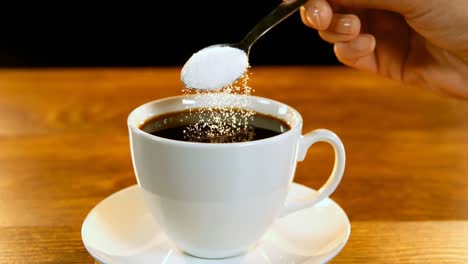 cuchara de azúcar vertida en una taza de café 4k