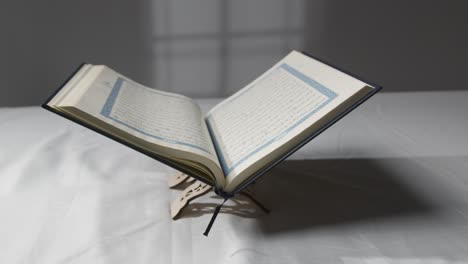 a handheld tracking shot of the quran on covered surface