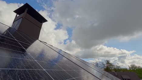 timelapse of rain clouds reflected on rooftop solar panels in suburban setting with speckled blue sky