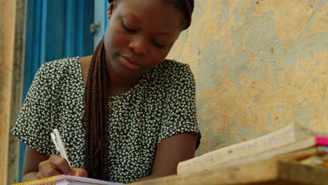 Tomando-Algunas-Notas-De-Un-Libro-Mientras-Estudia,-Una-Joven-Se-Está-Educando-Para-Cerrar-Las-Brechas-De-Género-En-Kumasi,-Ghana,-África