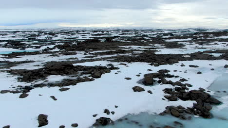 Beautiful-white,-black-and-icy-blue-landscape-in-north-Iceland,-aerial-shot