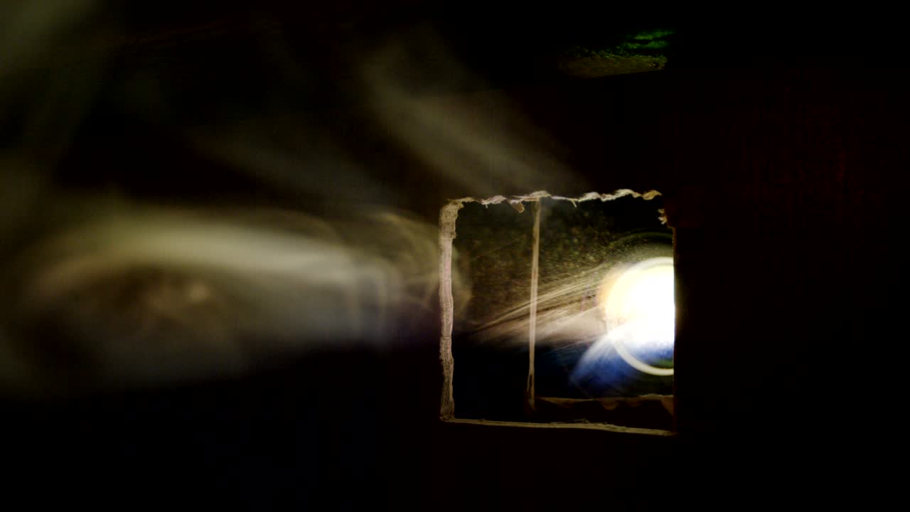 el humo ligero se dispersa en la sala contra el proyector