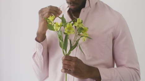 man holding and touching flowers