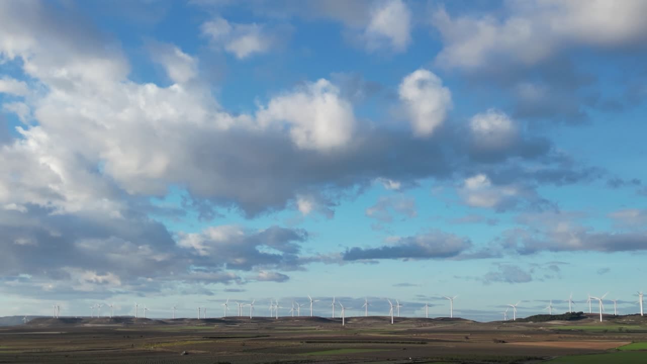 Scan across blue sky with interesting clouds and wind turbines.
