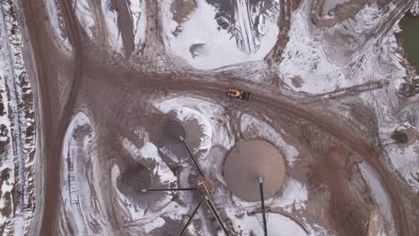 Top-Down-View-of-Gravel-Pit,-Open-Pit-Mining-With-Working-Front-End-Loader---Truck-Shot