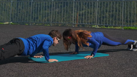 couple doing push-ups outdoors