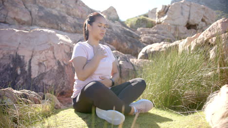 practicing mindfulness and breathing exercises, woman meditating outdoors on mountain hike