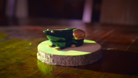 close-up of a handcrafted green wooden frog figurine