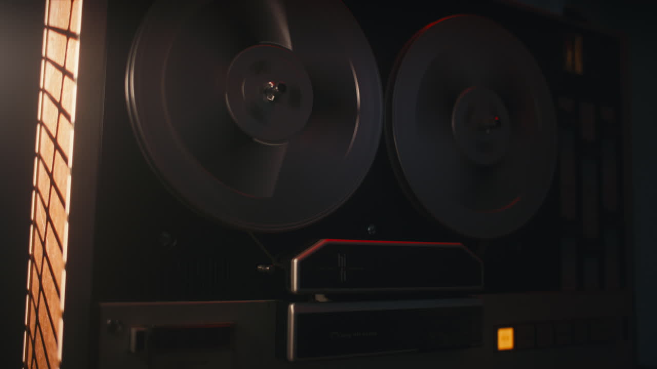 A vintage tape recorder spinning spools in a red blinking light