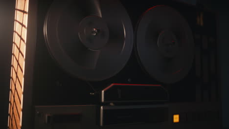a vintage tape recorder spinning spools in a red blinking light