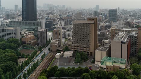 High-above-timelapse-of-Tokyo-skyline-with-skyscrapers-in-distance-and-traffic---tilt-up-shot