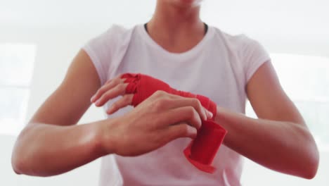mujer caucásica poniendo correa alrededor de sus muñecas