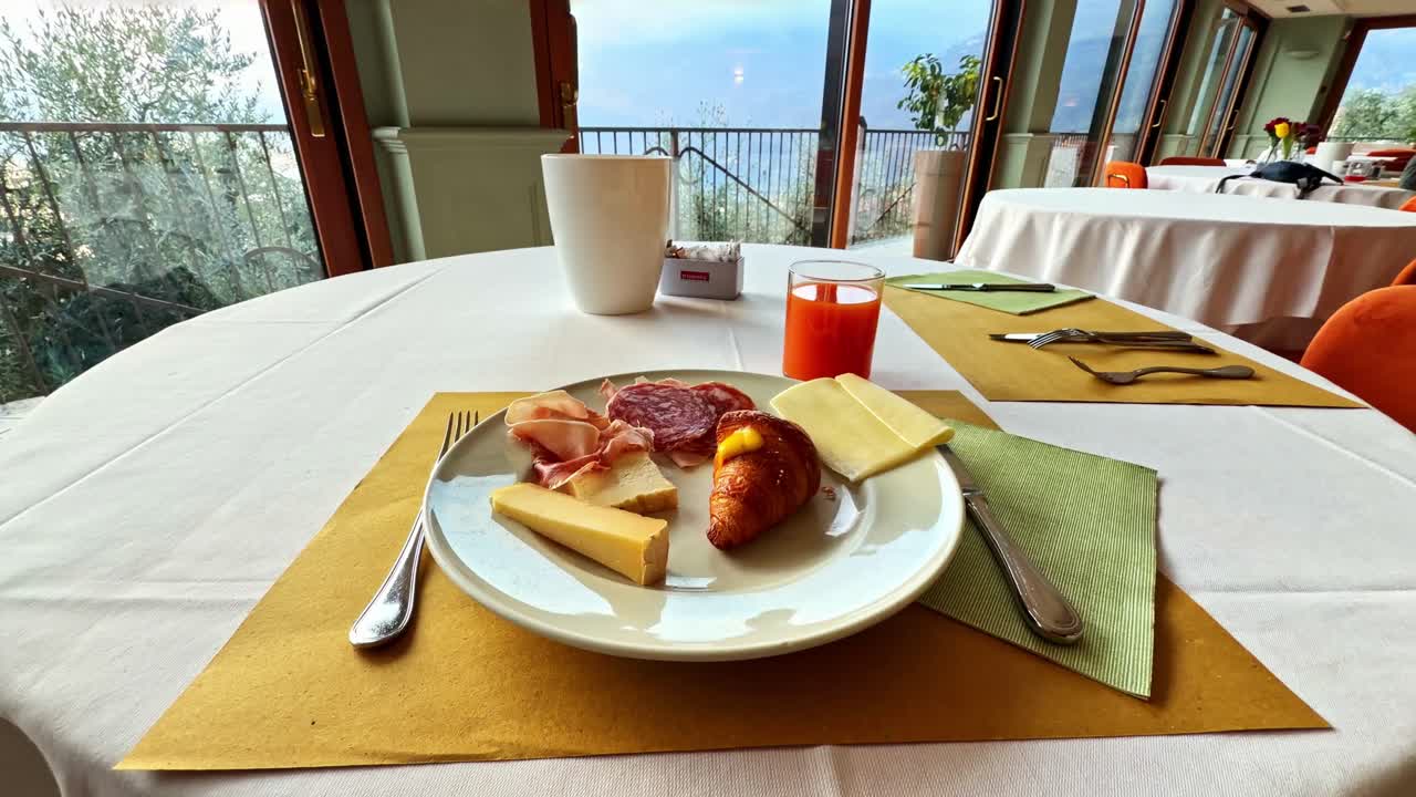 Frühstück auf einem Tisch mit malerischem Blick auf den Iseosee von einem Hotelrestaurant aus – POV-Aufnahme