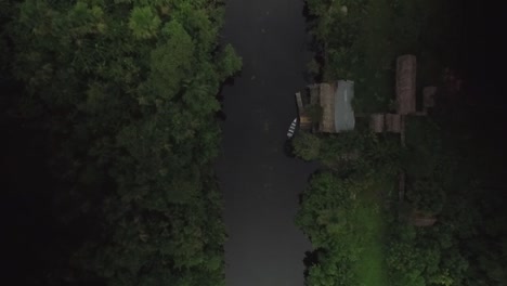 From-the-top-view-of-an-indigenous-cabin-next-to-a-river-in-the-middle-of-the-rainforest