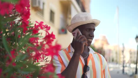 content black talking on smartphone near flowers