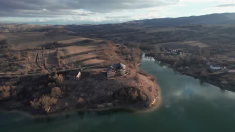 Casa-Abandonada-A-Orillas-Del-Lago-Rodeada-Por-El-Rígido-Paisaje-Invernal