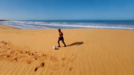 man playing soccer on a wide sandy beach with ocean and dunes