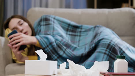 Tired-woman-using-smartphone-on-the-sofa