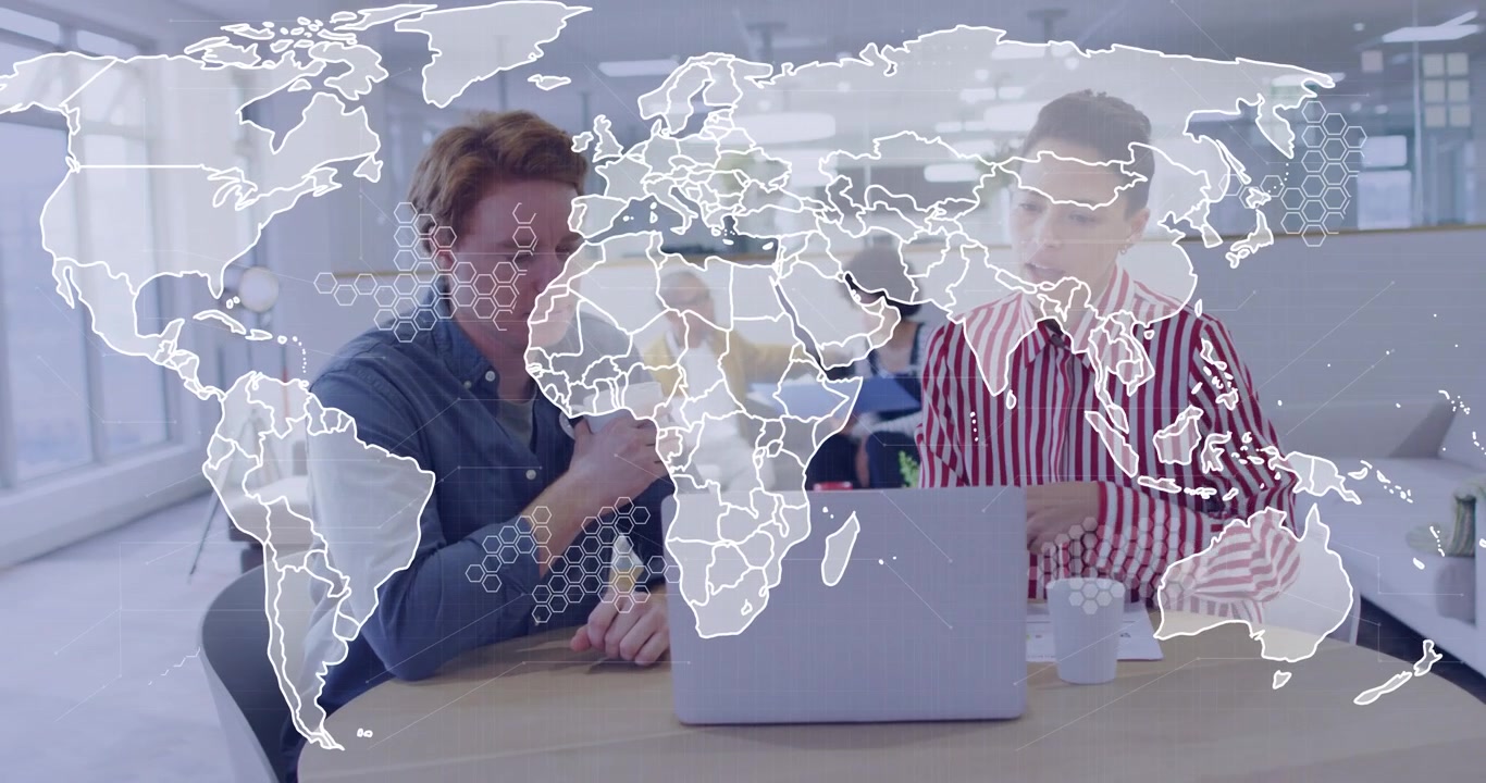 Dois funcionários bebendo de caneca e apontando para a tela do laptop, com hexágonos de mapa-múndi surgindo para negócios.