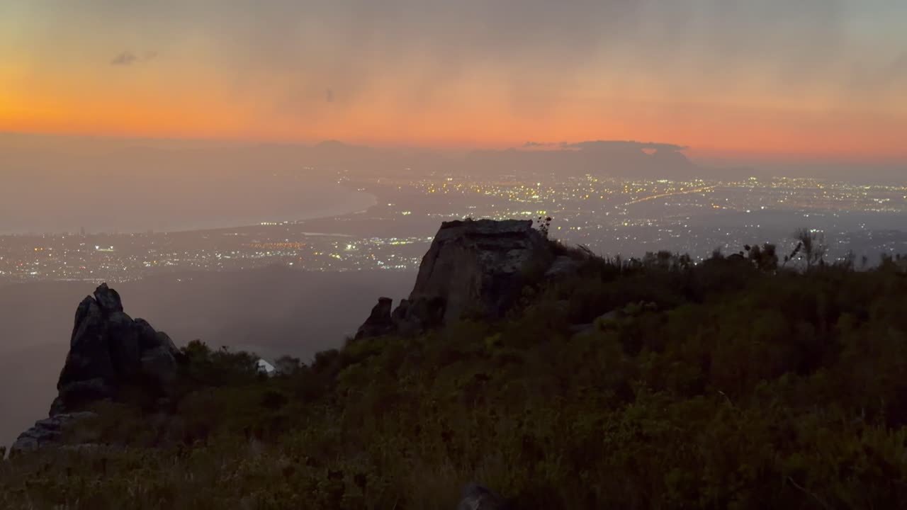 Tramonto sulla montagna che domina una città. Somerset West, Città del Capo, Sudafrica