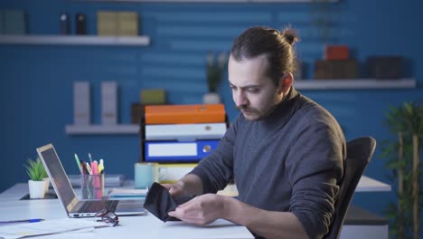 el hombre de negocios que mira su billetera se frustra.