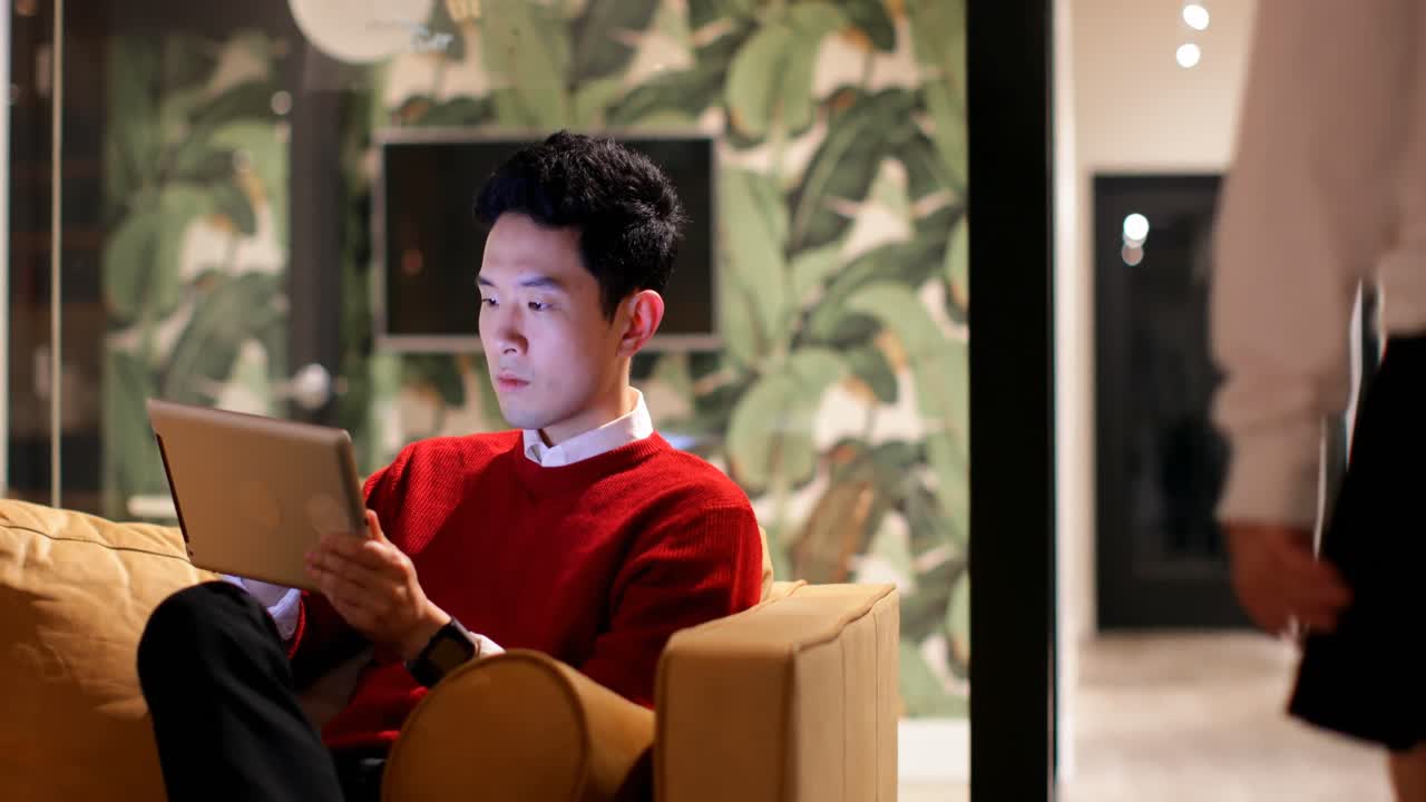 사무실 4k의 소파에 디지털 태블릿을 사용하는 남성 임원