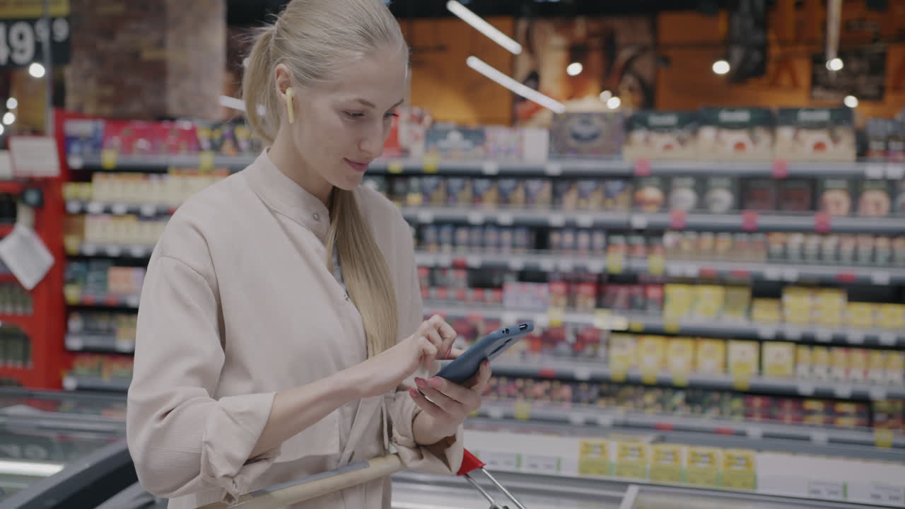 Woman using mobile phone in supermarket