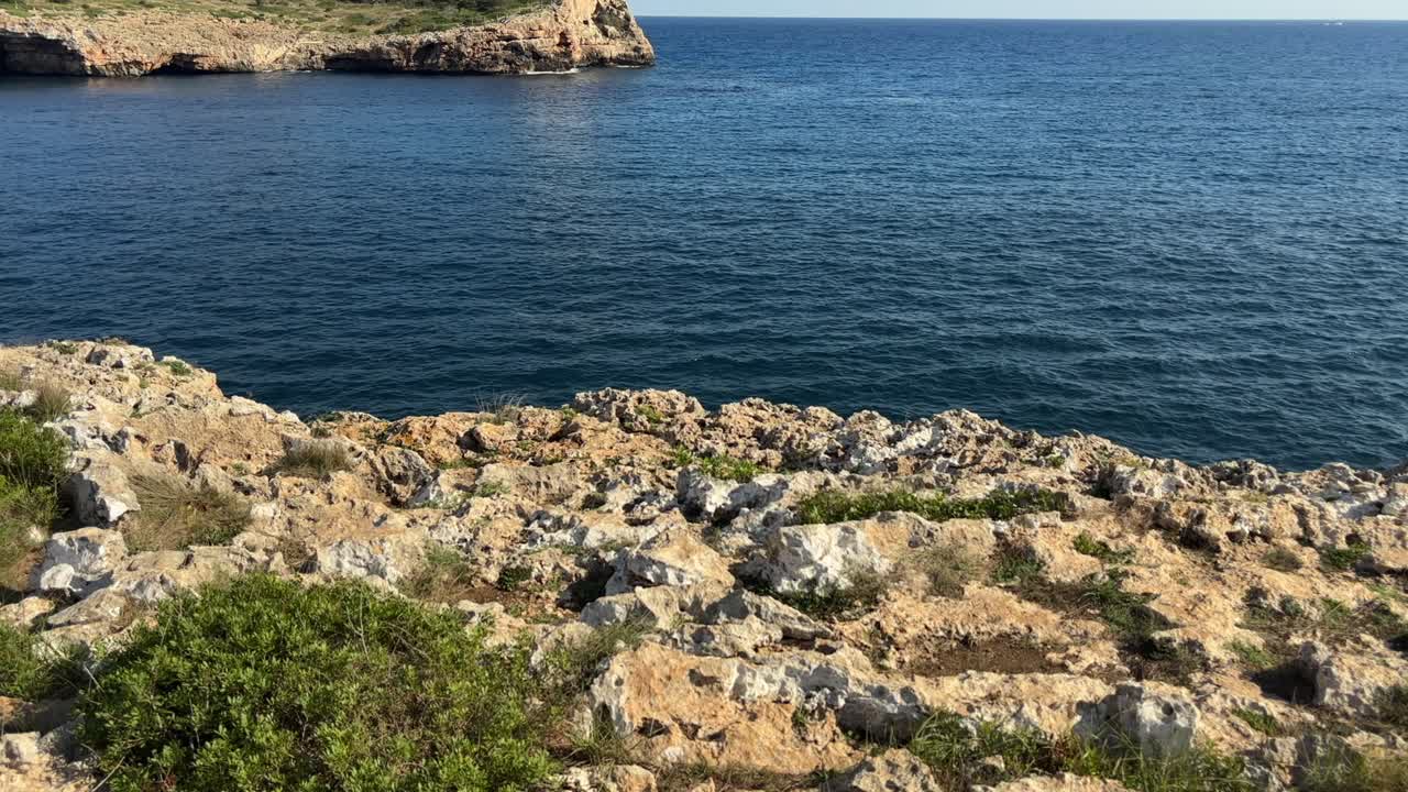 В Кала-Са-Кова-Форадада на потрясающем побережье острова Майорка в Испании суровые известняковые скалы встречаются с глубоким синим морем