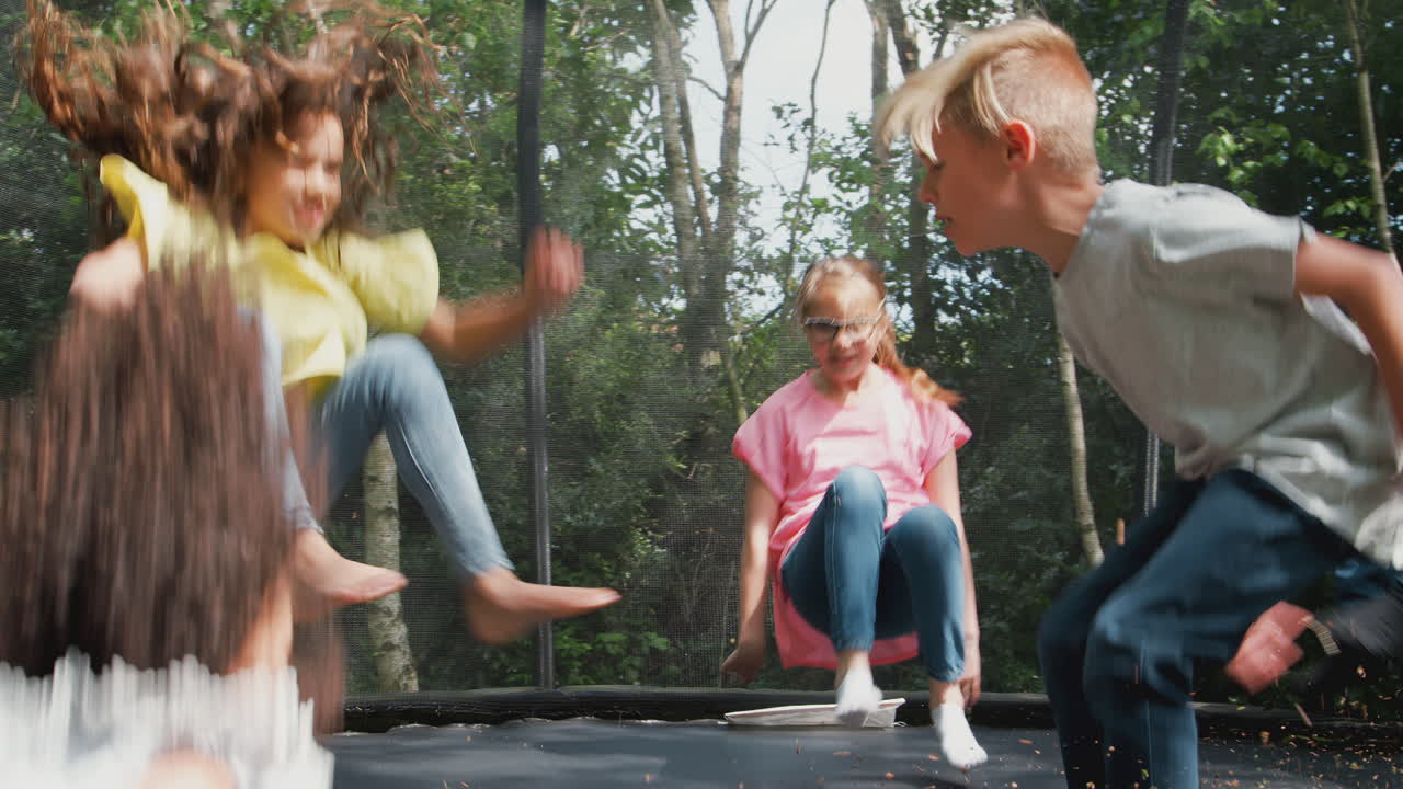 grupo de niños divirtiéndose con amigos saltando en el trampolín en el jardín
