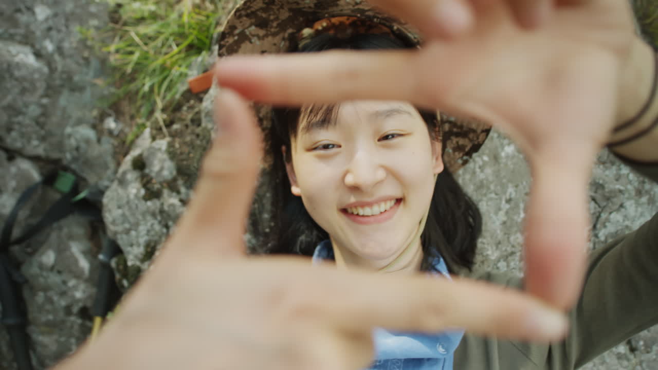 Happy Asian Tourist Looking through Fingers Square