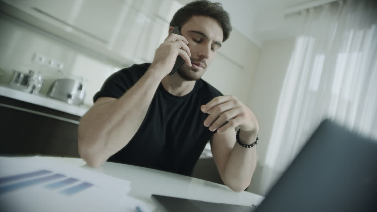 Uomo arrabbiato che telefona in cucina. Persona frustrata che parla al telefono cellulare