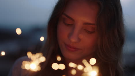 Nahaufnahme-Wunderkerzen-Porträt-Einer-Attraktiven-Kaukasischen-Frau,-Die-Silvester-Feiert-Und-Die-Feierlichkeiten-Zum-Unabhängigkeitstag-Am-Strand-Bei-Sonnenuntergang-Genießt