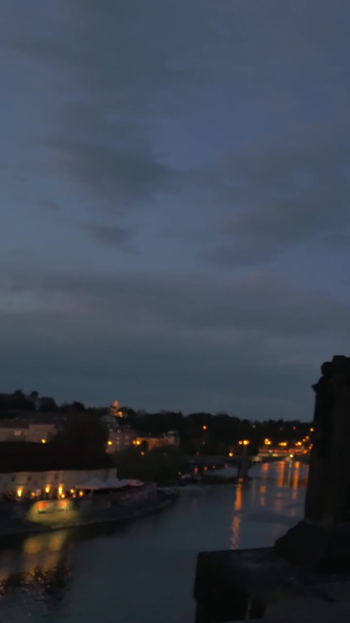 Panorama Noturno de um Rio Urbano com Luzes Brilhantes e Estátua