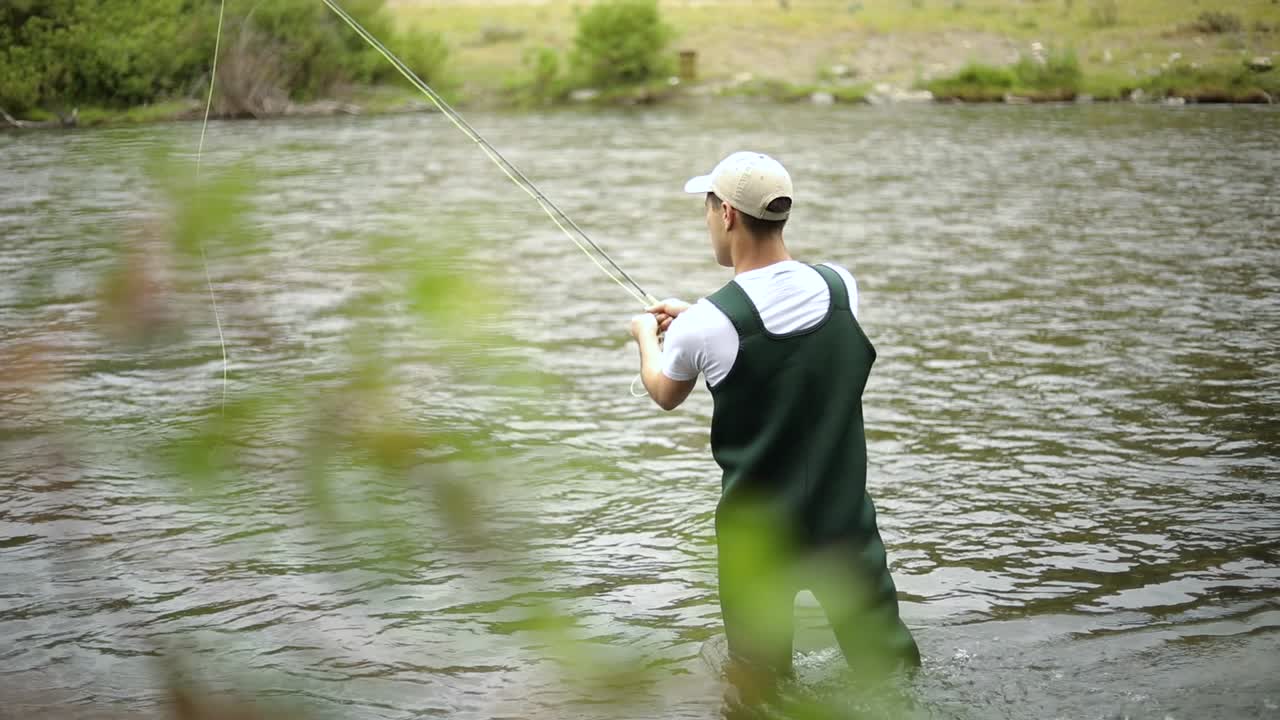Rekaman seorang pemancing pria Kaukasia sedang melempar kailnya saat fly fishing-4