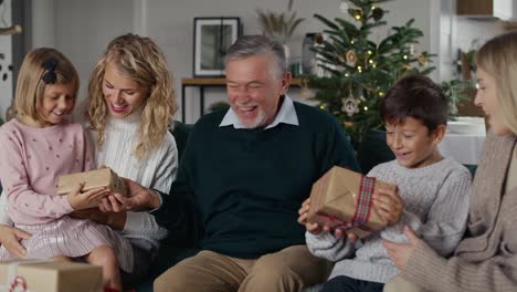 caucasian grandfather giving christmas presents for his grandchildren.