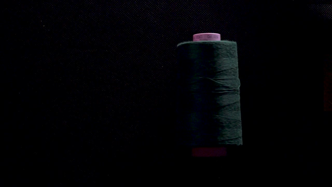 carrete de hilo en rollo de bobina color en fondo negro movimiento lento
